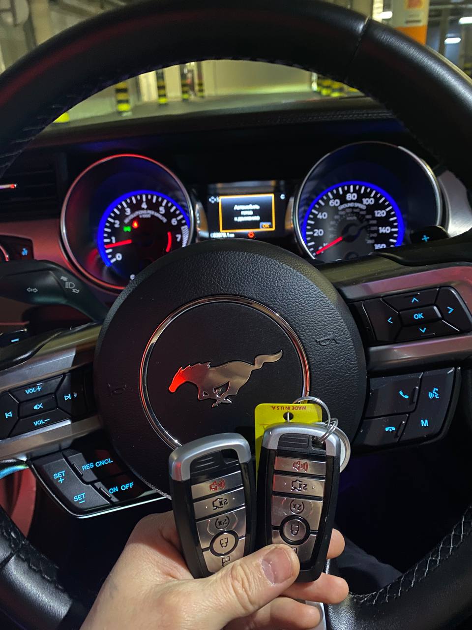 Готовые ключи для Ford Mustang в руке мастера у автомобиля клиента